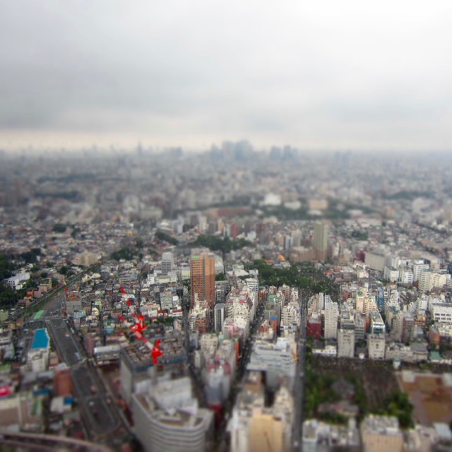 A photo of a sliver of Tokyo through a rainy window using pseudo tilt shift photography to make everything look tiny
